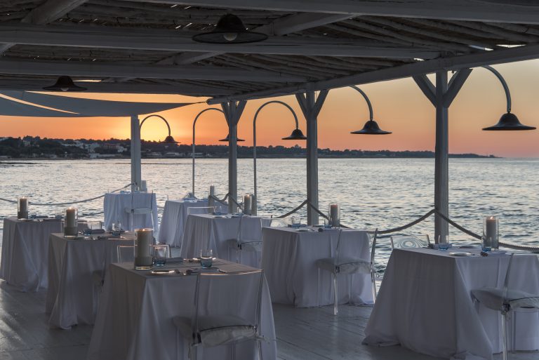 Set tables for dinner in the terrace of restaurant sale Blu at La Peschiera in Monopoli
